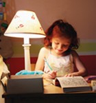 Girl reading by lamp