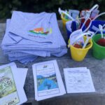 T-shirts, buckets, and Discover Passes displayed on a table.