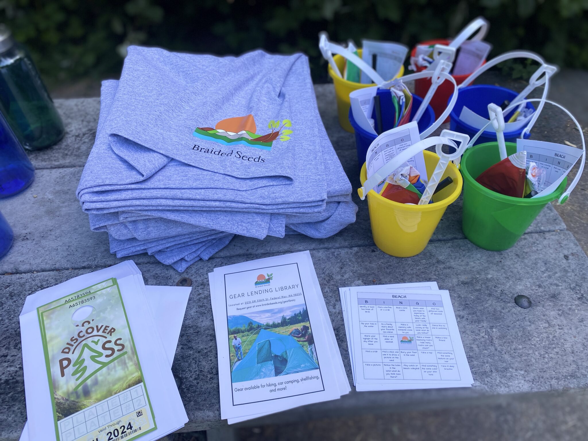 T-shirts, buckets, and Discover Passes displayed on a table.