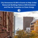 Text reads: City announces $3.5 million in grants to help under-resourced buildings reduce greenhouse gas emissions and plan for the transition to clean energy. Some buildings are in the background.