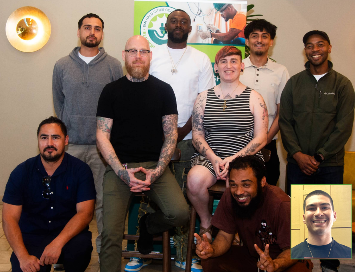 Top Graduates standing in front of Electrical Pathway Program Sign