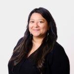 Professional image of new Acting OSE Director Lylianna Allala in black shirt with long dark hair and earrings